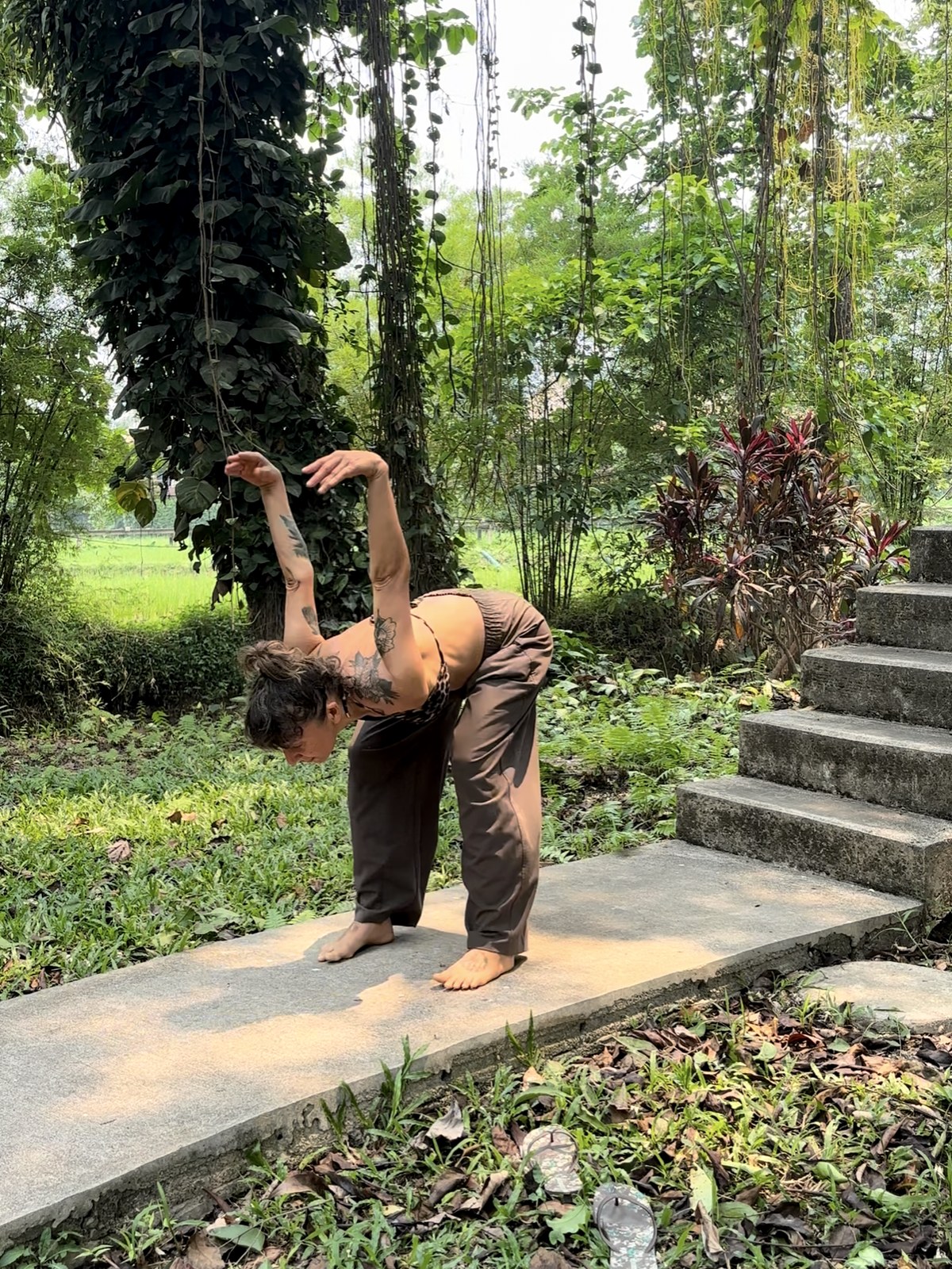 Lola coordinating shoulders, spine, and breath in a garden movement practice