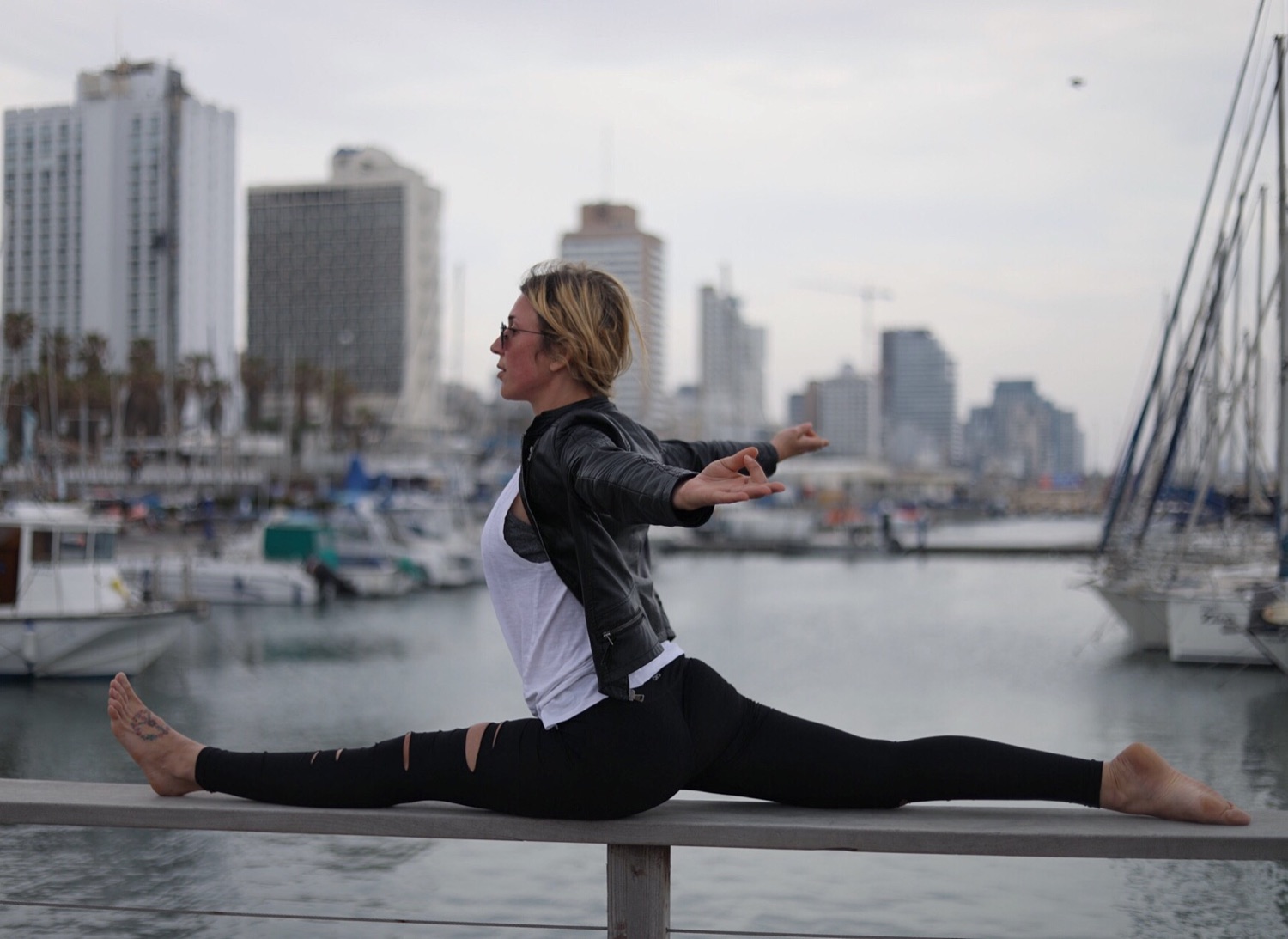 Lola practicing a split on a railing by a city marina