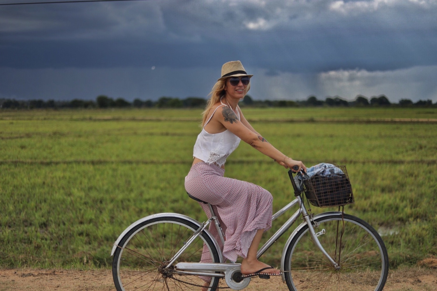 Lola riding a bicycle through an open green landscape