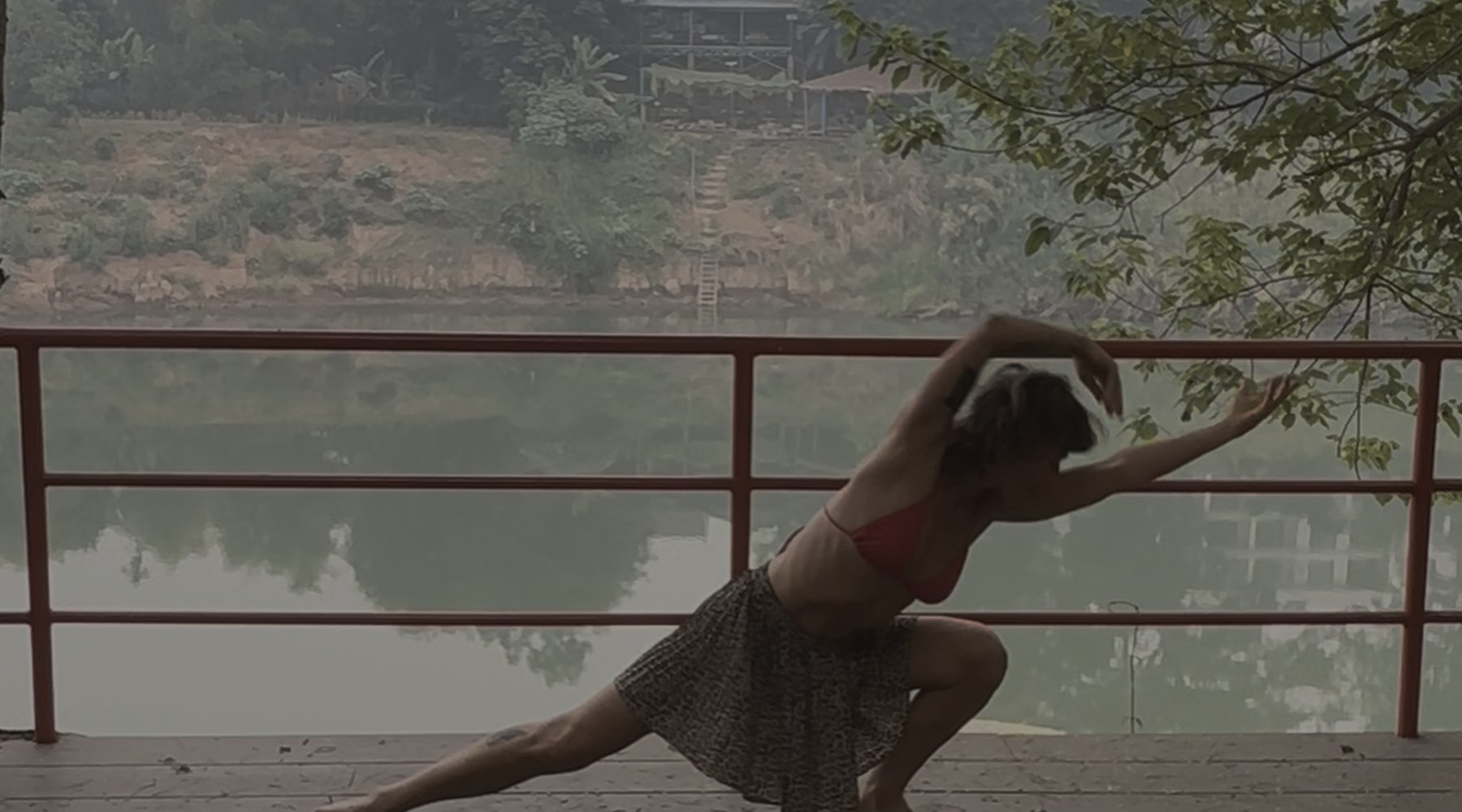 Lola integrating Dragon Wings movement into a quiet balcony practice beside water