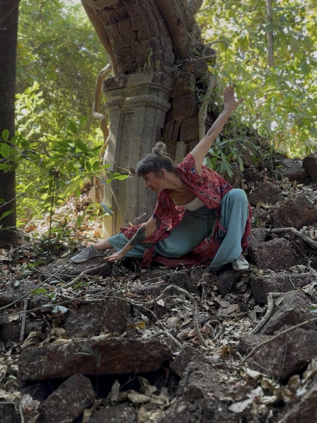 Lola seated in an old stone ruin during movement exploration